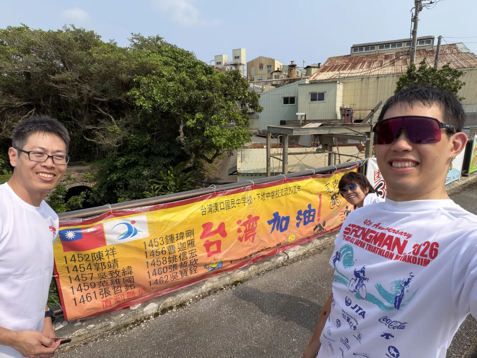 Pre-race photo along the bike course with the cheering banner Shimoji Junior High students made. Every Taiwanese competitor’s number and name is on it